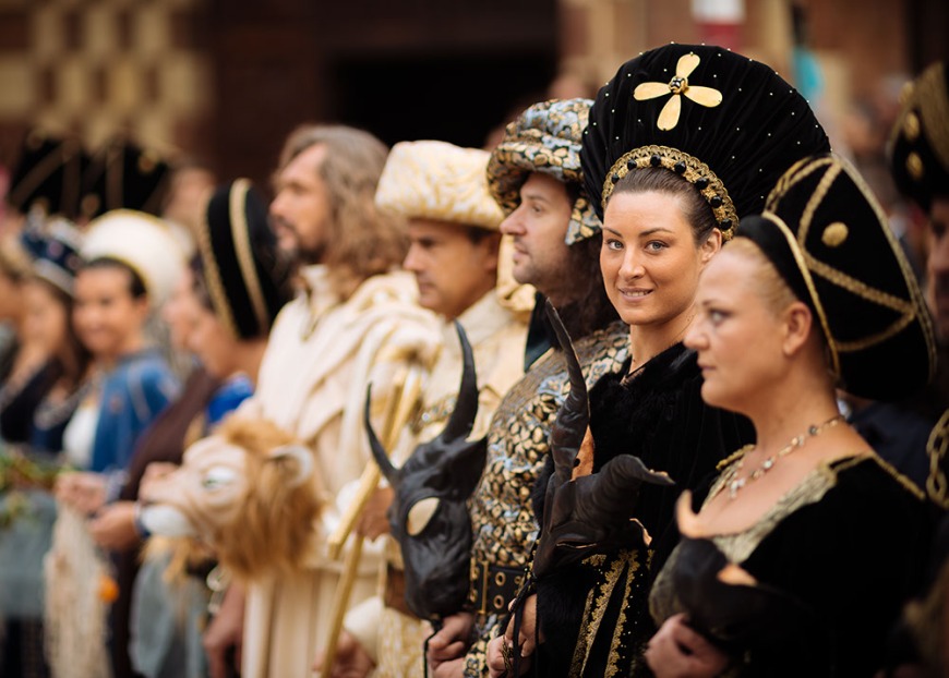 People dressed in traditional medieval costume gather in Piazza Cathedral for a blessing ahead of the Palio di Asti